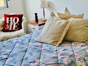 ein Bett mit Kissen darauf im Schlafzimmer in der Unterkunft Elegante apto en corazón Pocitos in Montevideo