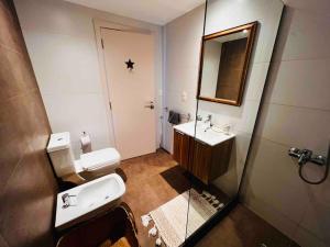 een badkamer met een wastafel, een toilet en een spiegel bij Elegante apto en corazón Pocitos in Montevideo