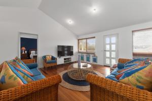 a living room with two couches and a television at Killarney Coastal Cottage in Rye
