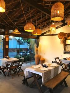 a dining room with tables and chairs and lights at Pousada Marujos in Búzios