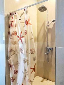 een douche met een douchegordijn in de badkamer bij Art & Soul Villa in Pacific Harbour