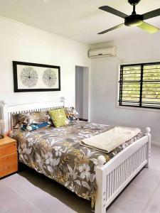 una camera con letto e ventilatore a soffitto di Art & Soul Villa a Pacific Harbour