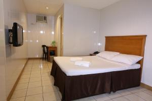 een slaapkamer met een bed met twee handdoeken erop bij Value Star Inn in Dagupan +15 foto's