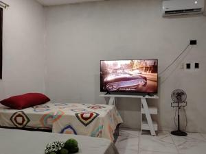a room with a flat screen tv on a white wall at La Casa de Amelia in Puerto Baquerizo Moreno