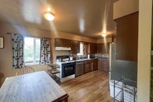 eine große Küche mit Holzböden und Edelstahlgeräten in der Unterkunft Hodges Hill Yosemite House in Oakhurst