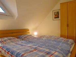 une chambre avec un lit avec une couette bleue dans l'établissement Haus Tante Clara Skipperkoje, Whg 20, Kukshörner Weg 8b, à Dangast