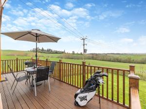 a wooden deck with a table and an umbrella at Church View - Uk46896 in Kinlet