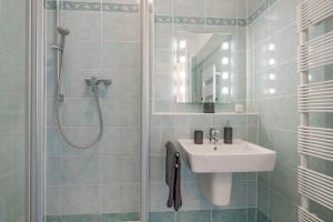 bagno bianco con lavandino e doccia di Strandvillen Wald & See - 04 a Zinnowitz