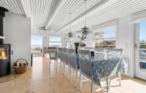 a dining room with a table and chairs and a fireplace at Cozy Home In Asnæs With House Sea View in Asnæs