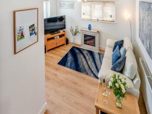 a living room with a white couch and a fireplace at Open Hearth Cottage in Cardiff