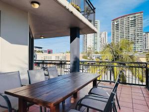 a wooden table and chairs on a balcony at Seaside Oasis 2Beds Apt with Free Parking in Gold Coast