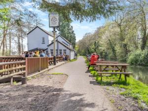 a building with a clock on it next to a river at Open Hearth Cottage in Cardiff