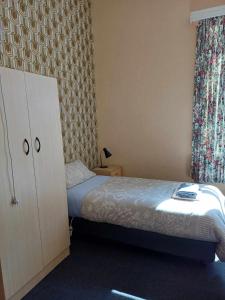 a small bedroom with a bed and a dresser at PETERBOROUGH HOTEL in Peterborough