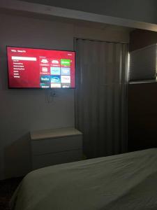 ein Schlafzimmer mit einem großen Bildschirm an der Wand in der Unterkunft Villa Orquídea 4 in Humacao + 7 Fotos