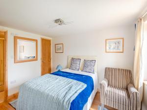 a bedroom with a bed and a chair at River Cabin in Little Baddow