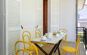 a table with yellow chairs on a balcony at Amazing Apartment In Montefelcino in Montefelcino