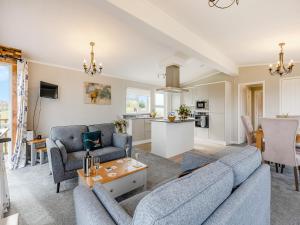 a living room with two blue couches and a kitchen at Park View - Uk46898 in Kinlet
