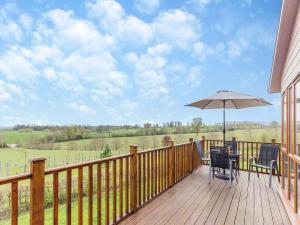 a wooden deck with a table and an umbrella at Park View - Uk46898 in Kinlet