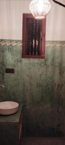 a bathroom with a sink and a mirror and a window at San-Khara in Ahangama