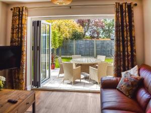 a living room with a sliding glass door with a table and chairs at Farmers Rest in Sutton