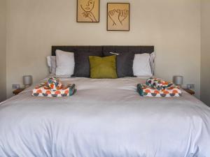 a large white bed with two pillows on it at Farmers Rest in Sutton