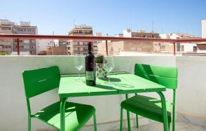 a green table with a bottle of wine and two chairs at Awesome Apartment In Torrevieja in Torrevieja
