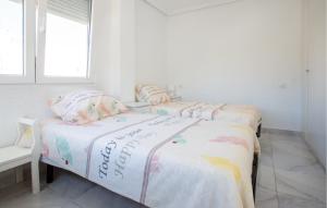 two twin beds in a white room with a window at Awesome Apartment In Torrevieja in Torrevieja