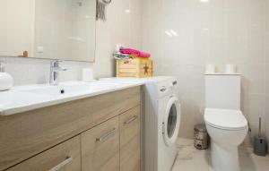 a bathroom with a washing machine and a sink at Stunning Apartment In Torrevieja With Kitchen in Torrevieja