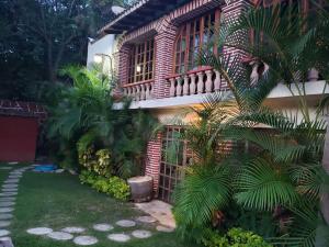 a house with a palm tree in front of it at Casa Temazcal Cuernavaca - Con Alberca y Temazcal in Jiutepec