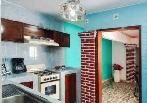a kitchen with a white stove and blue walls at Casa Temazcal Cuernavaca - Con Alberca y Temazcal in Jiutepec