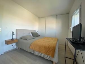 1 dormitorio con 1 cama, escritorio y TV en Maison Fouras, 4 pièces, 4 personnes - FR-1-709-74, en Fouras