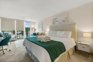 1 dormitorio con 1 cama grande con manta verde en Sandestin Bayfront Studio with balcony and breathtaking views, en Destin