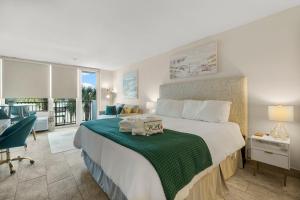 una camera da letto con un grande letto con una coperta verde di Sandestin Bayfront Studio with balcony and breathtaking views a Destin