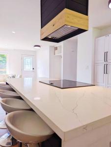 a kitchen with a counter with a row of stools at The Lilac Bungalow in Kingston