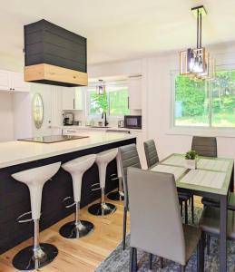 a kitchen with a counter and a table and chairs at The Lilac Bungalow in Kingston