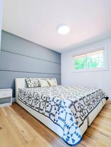 een slaapkamer met een bed met een blauwe muur bij The Lilac Bungalow in Kingston