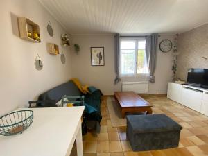 uma sala de estar com um sofá e uma mesa em Appartement La Tranche-sur-Mer, 2 pièces, 4 personnes - FR-1-22-334 em La Tranche-sur-Mer
