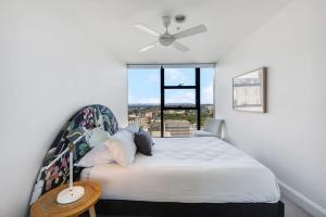 - une chambre avec un lit et un ventilateur de plafond dans l'établissement City Bloom - A Cosy Haven in Melbourne's Epicentre, à Melbourne