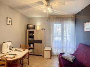 ein Wohnzimmer mit Tisch und Couch in der Unterkunft Studio Charmant à Lamalou-les-Bains, Balcon, Wifi, Proche Thermes et Nature - FR-1-451-208 in Lamalou-les-Bains