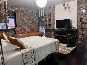 ein Wohnzimmer mit 2 Betten und einem TV in der Unterkunft Faaora Lodge, little paradise in Haapiti