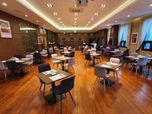 a restaurant with tables and chairs in a room at Busan Business Hotel in Busan