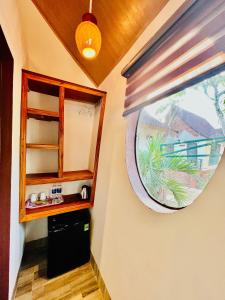 a kitchen with a round window and a black refrigerator at Tropical Valley Homestay in Phong Nha