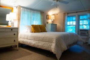 een slaapkamer met een bed, een dressoir en een raam bij The Old Stone Cottage at Tippy in North Webster