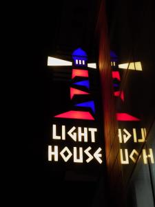 a lit up light house sign next to a building at Light House By Leisure Hospitality in Rishīkesh