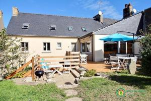 a house with a patio with a table and umbrella at Villa cafe marrec 8 in Port-Louis
