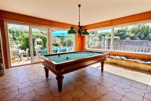 a pool table in a large room with windows at Villa cafe marrec 8 in Port-Louis