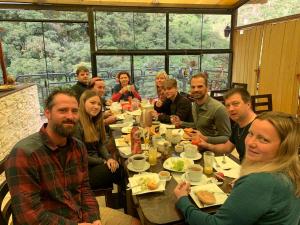 un grupo de personas sentadas alrededor de una mesa comiendo en RUMIQOLQA Machupicchu Hotel en Machu Picchu