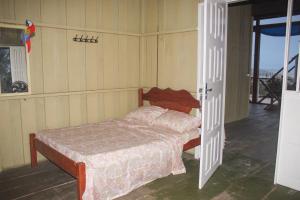 a bedroom with a bed and an open door at Nossa Casa de Praia in Ajuruteua