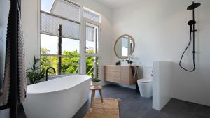 a bathroom with a tub and a sink and a mirror at The Welcome Paddock in Hepburn
