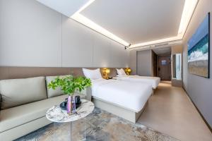 un soggiorno con divano e letto di Kunming Yuxi Hotel a Kunming Altre 23 foto